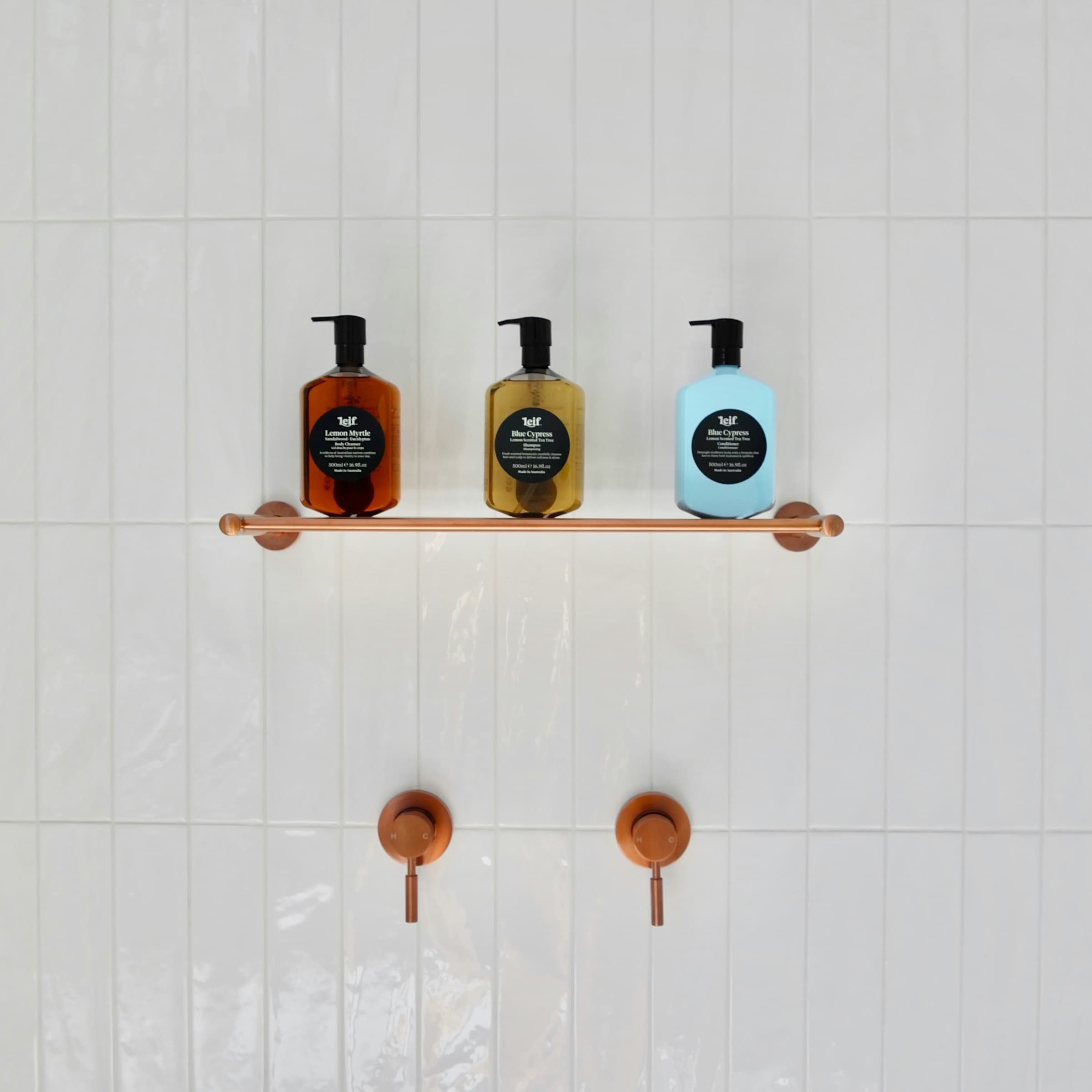 Bathroom shelf with copper fittings and neatly arranged bottles
